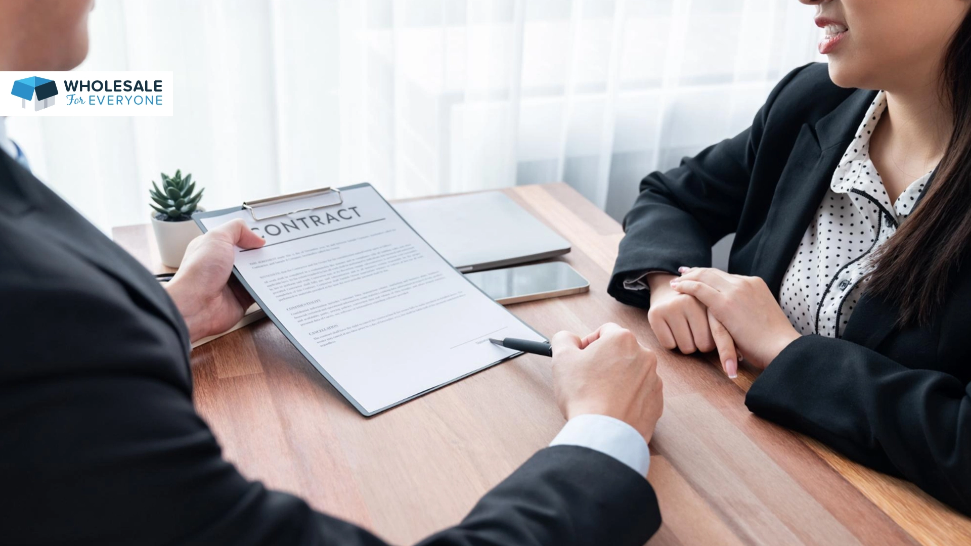 The photo shows a attorney holding a contract and showing it to a lady.