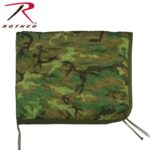 A camouflage-patterned blanket is displayed flat with stitched lines across its surface the blanket has drawstrings on one side and is set against a plain background.