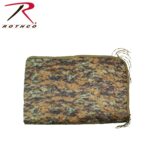 A camouflaged blanket with a quilted design lies flat displaying a pattern of greens browns and blacks its edges are finished with a solid color trim and loose threads fray from one side.