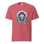 A pink t-shirt features a colorful graphic of an alien holding two cannabis joints surrounded by leaves with the word WEED prominently displayed below the alien image.