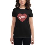 A black t-shirt features a red heart design filled with intricate patterns and the word Love prominently displayed in white. The wearer stands in a neutral setting.