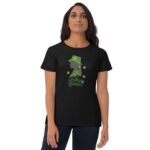 A woman stands wearing a black t-shirt featuring a green graphic silhouette of a woman with a green hat and clovers the text reads lucky woman.