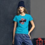 A young woman poses wearing a bright blue t-shirt adorned with the word "LOVE" and floral graphics against a dark textured wall with a hint of industrial elements nearby.