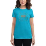 A woman wears a bright turquoise t-shirt featuring festive graphics including shamrocks and top hats with the text "Happy St. Patrick's Day" in a casual setting.