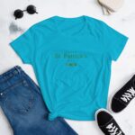 A turquoise t-shirt is displayed with the text "HAPPY St. Patrick's DAY" in a darker shade. Nearby are rolled-up blue jeans  black sneakers  and sunglasses on a light background.