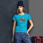 A young woman poses wearing a bright blue t-shirt with the text I LOVE MY GREENS HAPPY ST PATRICK against a textured dark background with a chain in the lower right corner.