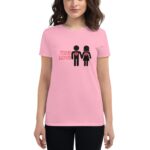 A woman wears a pink t-shirt featuring two stick figures holding hands with red hearts inside their chests accompanied by the text TRUE LOVE  expressing affection in a casual setting.