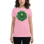 A person wears a pink t-shirt featuring a circular green design with shamrocks and the text "HAPPY S. Patrick's DAY" in white  celebrating St. Patrick's Day.