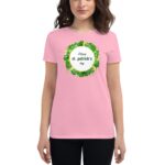 A person wears a pink t-shirt featuring a circular design with the text Happy st. patrick's day surrounded by green clovers  suggesting a festive celebration for the holiday.