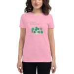 A woman wears a pink t-shirt featuring green shamrocks and a poem. The shirt conveys a festive theme celebrating St. Patrick's Day  adding a cheerful touch to her outfit. The text reads: