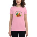 A woman wears a pink t-shirt featuring a pot of gold surrounded by green and orange elements with the text "ST. PATRICK'S DAY" and a message about finding the pot of gold.