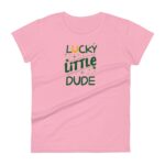 A pink t-shirt displays the text Lucky Little Dude in green with a horseshoe icon above the word Lucky and sparkles surrounding the text creating a playful design.