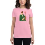 A woman is wearing a pink t-shirt featuring an illustration of Saint Patrick holding a staff with a circular symbol with the text Saint Patrick 20 24 below the image.