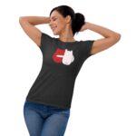 A woman is smiling while stretching with her arms raised wearing a dark shirt featuring a graphic of two cartoonish gloves one red and one white against a plain background.