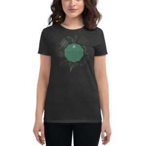 A woman is wearing a dark t-shirt featuring a green design with tea-related elements. The text reads Life's like a cup of tea  suggesting a thoughtful sentiment.