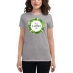 A woman wears a gray t-shirt featuring a decorative graphic with green clovers and gold elements that reads Happy st. patrick's day  celebrating the holiday's theme.