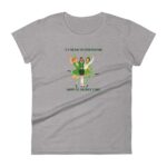 A gray t-shirt features three cheerful women in green outfits celebrating St. Patrick's Day by dancing together surrounded by small clovers and the text "IT'S THE DAY OF GOOD FORTUNE HAPPY ST. PATRICK'S DAY"