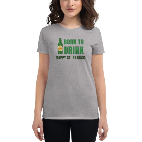 A person wears a gray t-shirt featuring a graphic of a beer bottle and text that reads BORN TO DRINK HAPPY ST. PATRICK celebrating St. Patrick's Day in a casual setting.