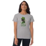 A woman stands wearing a gray t-shirt featuring a green silhouette of a woman in a hat with the words Lucky Woman and green leaves surrounding the design.