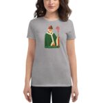 A person wears a gray t-shirt featuring a stylized illustration of Saint Patrick holding a cross staff with a green and white robe against a neutral background. Text reads Saint Patrick 20 24.