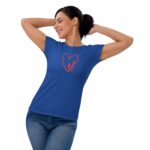 A woman is smiling and stretching with her arms behind her head while wearing a blue t-shirt featuring a red heart design with the word love inside it. She is casually dressed.