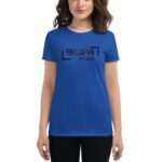 A person wears a blue t-shirt displaying the text BELIEVE IN LOVE in bold black letters. The focus is on the shirt's message  conveying positivity and encouragement in a casual setting.