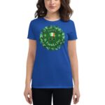 A woman wears a blue t-shirt featuring a green circular design with shamrocks and text that reads "HAPPY St. Patrick's Day" alongside a hat and glasses symbolizing the celebration.
