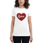White t-shirt features a large red heart design filled with intricate patterns and the word Love prominently displayed in white across the center while a woman stands wearing it.