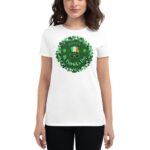 A woman wears a white t-shirt featuring a circular design with green clovers and the text Happy St. Patrick's Day  alongside a design of a hat and glasses  celebrating the holiday.