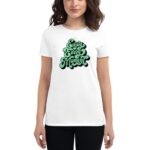 A person wears a white t-shirt featuring the text "Enjoy Every Moment" in green stylized lettering  standing against a plain light background.