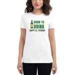 A woman wears a white t-shirt displaying the text "BORN TO DRINK HAPPY ST. PATRICK" alongside an image of a beer bottle. She smiles in a neutral background.