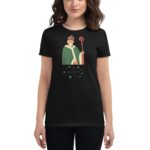 A woman wears a black t-shirt featuring a green-cloaked figure holding a staff with the word "LUCKY" and decorative shamrocks below  symbolizing a festive theme.