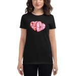 A woman is wearing a black t-shirt featuring a pink heart design divided into two sections with images resembling chocolates and desserts  presenting a playful and sweet theme.