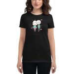 A woman wears a black t-shirt featuring a cartoon illustration of two characters with hearts around them  suggesting a theme of love or friendship in a casual setting.
