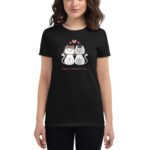 A woman wears a black t-shirt featuring two cartoon cats with heart motifs The text reads Happy Valentine's Day indicating a festive theme centered around love and affection.