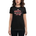 A woman is wearing a black t-shirt featuring the text "HAPPY VALENTINE'S DAY" in pink with flower designs  celebrating Valentine's Day in a casual style.