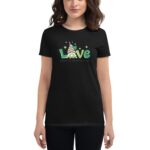 A person is wearing a black t-shirt featuring the text "Love" in green with a gnome graphic and small clovers alongside the phrase "Happy St. Patrick's Day" beneath it.