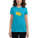 A woman wearing a bright turquoise t-shirt with a playful graphic of two yellow smiling olives. Above the olives  the text reads OLIVE YOU. The background is plain white.