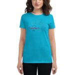 A woman wearing a bright turquoise t-shirt with the text "Happy Valentine's Day" in decorative font and surrounding hearts poses in a neutral background.