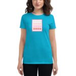A woman wears a bright turquoise t-shirt featuring a design with the word "XOXO" in varying colors and sizes resembling a stamp  against a neutral background.