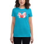 A woman is wearing a bright turquoise t-shirt featuring a graphic of whimsical characters holding a red heart with the word "LOVE." The setting appears casual and cheerful. Text above reads "A love like yours ador."