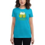 A woman is wearing a bright turquoise t-shirt featuring two beer mugs with foam and the text CHEERS!! in colorful lettering against a plain background.