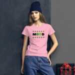 A young woman stands confidently  wearing a pink T-shirt with the word "MOOD" and emoticons. She pairs it with casual denim jeans and a dark beanie  in a dimly lit urban setting.