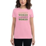 A woman wears a pink t-shirt displaying the text "LUCKY WOMAN LUCKY WOMAN" in varying styles and colors against a neutral backdrop  conveying a playful and positive message.