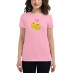 A woman is wearing a pink t-shirt featuring two cartoon olives with smiling faces. The text above them reads OLIVE YOU. She has shoulder-length dark hair and a neutral expression.