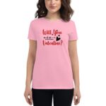 A woman wearing a pink t-shirt with the text "Will You Be My Valentine?" prominently displayed in red and black colors  standing against a neutral background.