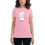 A woman wearing a pink shirt stands smiling while holding her hands together at chest level. The shirt features a cartoon character and the text You're in my heart.