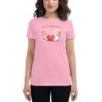 A woman wears a light pink t-shirt featuring a graphic of two gnomes holding a red heart with text that reads A love like gnome other and LOVE in bold letters.