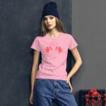 A model stands against a textured wall wearing a pink shirt with red cartoon cherubs and a heart design featuring the word love in the center with dangling red chains nearby