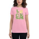 A woman wears a pink t-shirt featuring the word "LUCK" with a green design and a banner reading "ST. PATRICK'S DAY " surrounded by shamrocks  celebrating the holiday's theme.